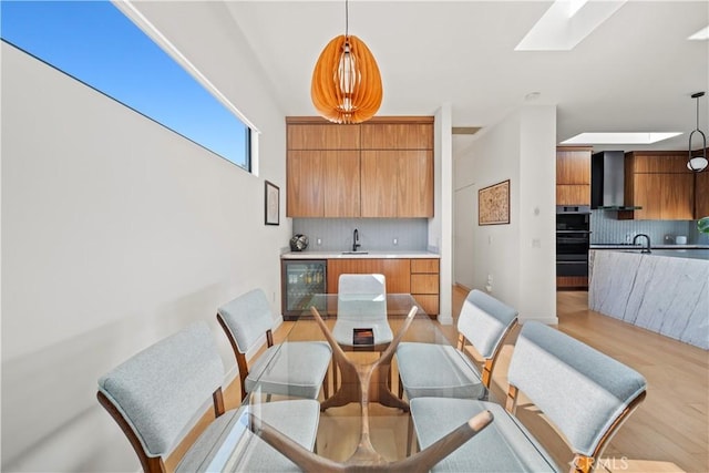 4756 Keniston Ave, View Park, CA 90043 - dining space with beverage cooler, light wood-style flooring, and a skylight