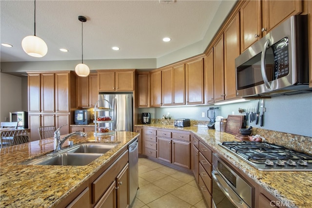 84692 Pavone Way, Indio, CA 92203 - kitchen with stainless steel appliances, a sink, hanging light fixtures, recessed lighting, and brown cabinetry