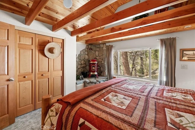 38855 Big Bear Blvd, Big Bear Lake, CA 92315 - bedroom with beam ceiling, light colored carpet, a wood stove, and wooden ceiling
