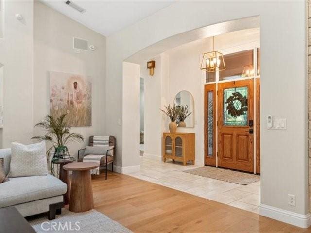 25179 68th Ave, Los Molinos, CA 96055 - foyer with a chandelier, arched walkways, light wood finished floors, and baseboards
