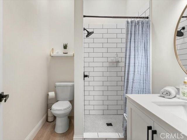 25179 68th Ave, Los Molinos, CA 96055 - full bath featuring a shower stall, toilet, wood finished floors, vanity, and baseboards