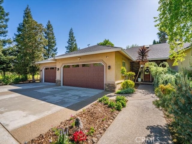 25179 68th Ave, Los Molinos, CA 96055 - ranch-style house featuring stucco siding, stone siding, driveway, and an attached garage