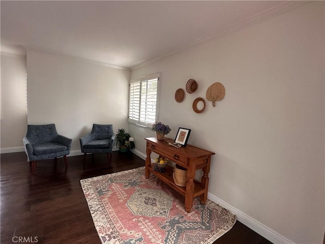 sitting room featuring wood finished floors, baseboards, and ornamental molding