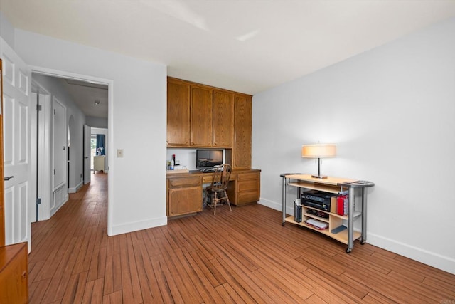 979 Canyon Heights Rd, Fallbrook, CA 92028 - home office featuring built in desk, baseboards, and wood finished floors