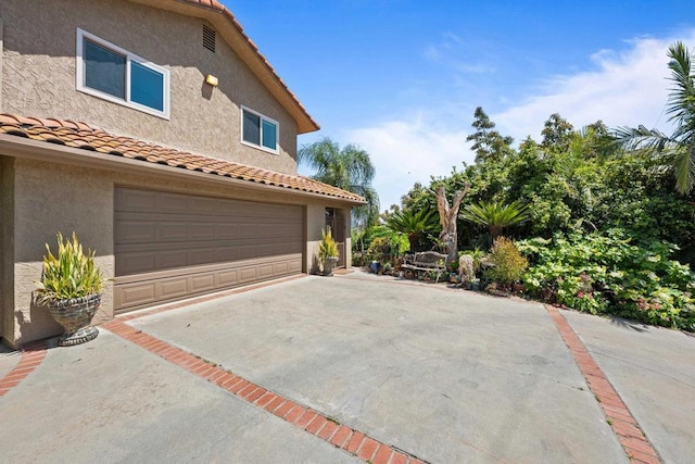 979 Canyon Heights Rd, Fallbrook, CA 92028 - view of property exterior with a garage, a tiled roof, stucco siding, and concrete driveway