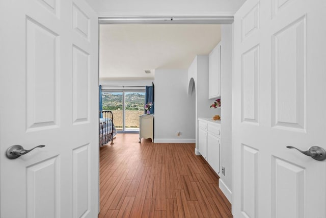 979 Canyon Heights Rd, Fallbrook, CA 92028 - hall with arched walkways, baseboards, and light wood-style floors