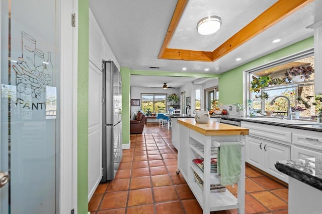 979 Canyon Heights Rd, Fallbrook, CA 92028 - kitchen with a sink, freestanding refrigerator, white cabinets, open floor plan, and a tray ceiling