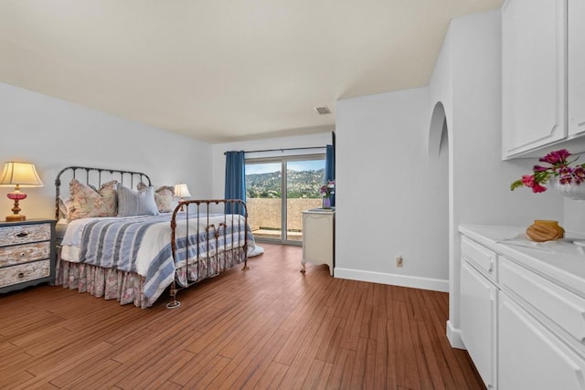 979 Canyon Heights Rd, Fallbrook, CA 92028 - bedroom featuring access to outside, arched walkways, light wood-style floors, and baseboards