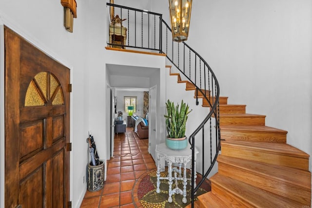 979 Canyon Heights Rd, Fallbrook, CA 92028 - foyer entrance with stairs, tile patterned flooring, a chandelier, a high ceiling, and baseboards
