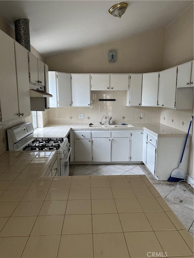 1940 E Walnut Crk, West Covina, CA 91791 - kitchen featuring white gas stove, vaulted ceiling, tile countertops, and decorative backsplash