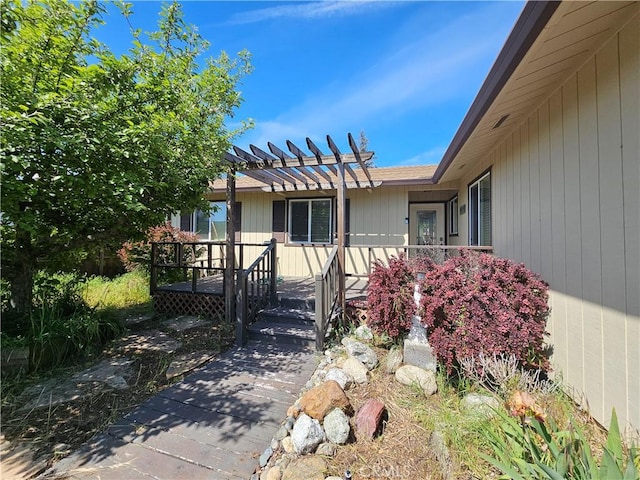 entrance to property with a pergola and a deck