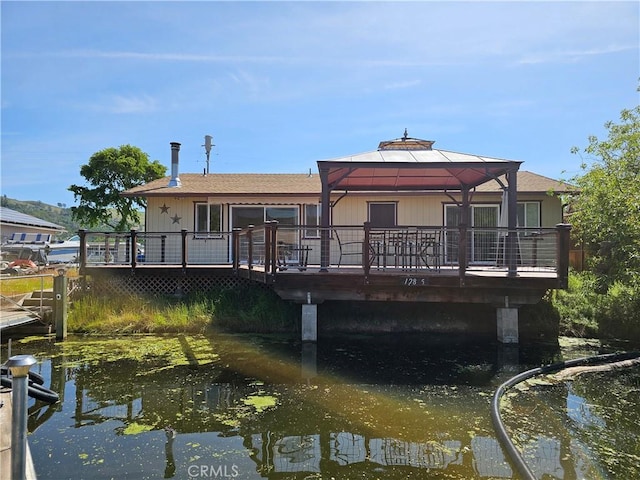 back of property with a gazebo and a wooden deck