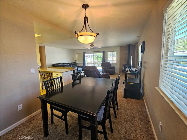 dining area featuring carpet flooring, baseboards, and ceiling fan