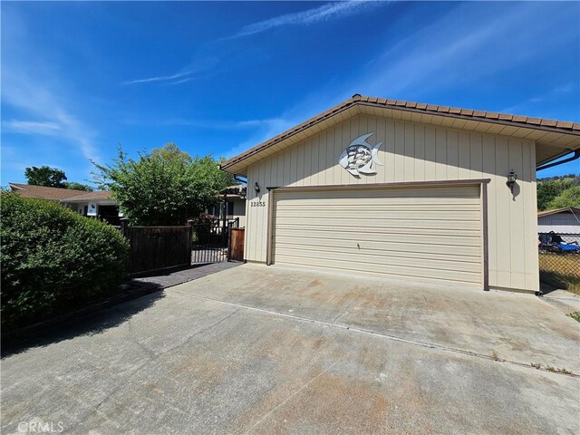 garage with fence and driveway