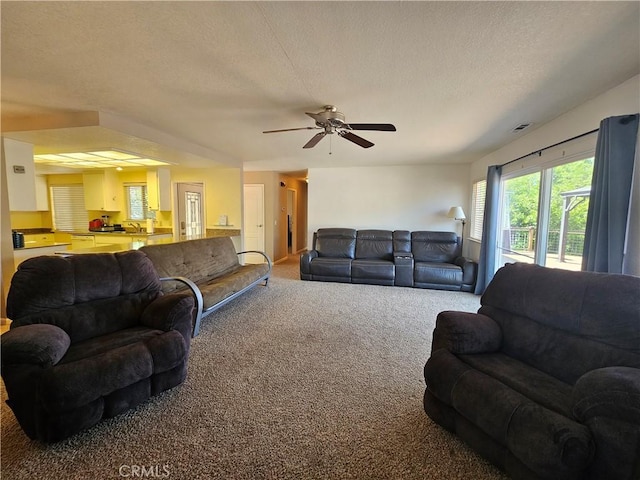 living room with carpet, a ceiling fan, and a textured ceiling