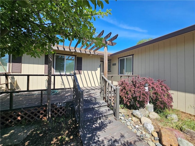 entrance to property with a deck and a pergola