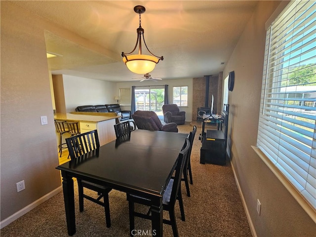 dining room featuring carpet, baseboards, and ceiling fan