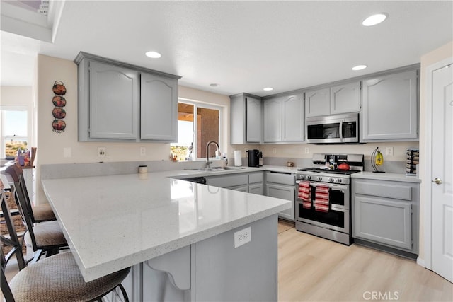 7138 Amanda Way, Hesperia, CA 92345 - kitchen with stainless steel appliances, a peninsula, healthy amount of natural light, a breakfast bar area, and recessed lighting