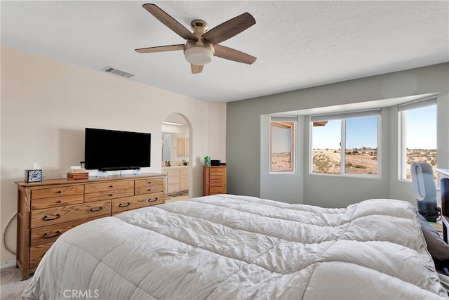 7138 Amanda Way, Hesperia, CA 92345 - bedroom with arched walkways, a ceiling fan, light carpet, and ensuite bath