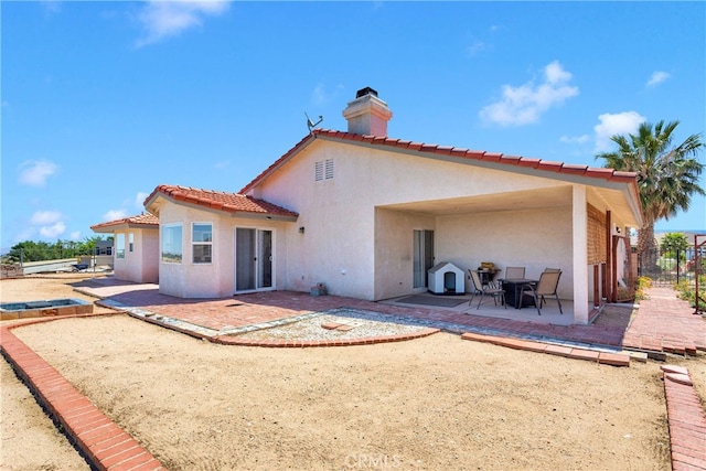 7138 Amanda Way, Hesperia, CA 92345 - back of house featuring stucco siding, a patio, a chimney, and a tiled roof