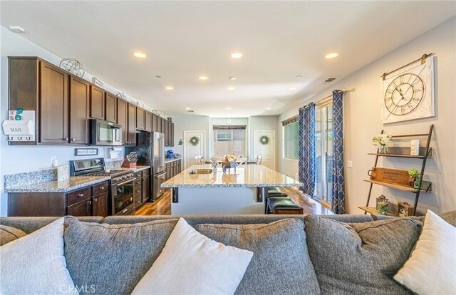 1357 Bannock St, Beaumont, CA 92223 - kitchen with appliances with stainless steel finishes, open floor plan, a center island with sink, and recessed lighting