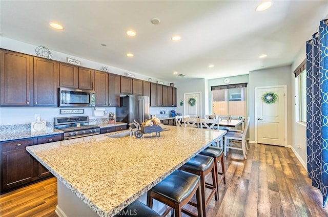 1357 Bannock St, Beaumont, CA 92223 - kitchen featuring stainless steel appliances, a sink, a breakfast bar, recessed lighting, and dark wood finished floors