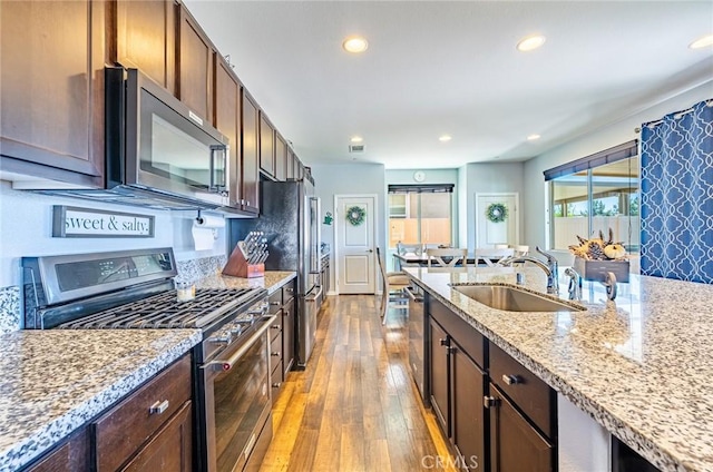 1357 Bannock St, Beaumont, CA 92223 - kitchen featuring stainless steel appliances, a sink, hardwood / wood-style flooring, recessed lighting, and light stone counters