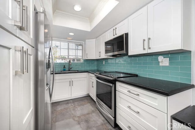 23391 La Crescenta Unit 270C, Mission Viejo, CA 92691 - kitchen with stainless steel appliances, ornamental molding, a raised ceiling, decorative backsplash, and white cabinetry