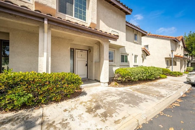 23391 La Crescenta Unit 270C, Mission Viejo, CA 92691 - view of exterior entry with stucco siding and a tiled roof