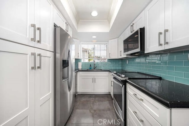 23391 La Crescenta Unit 270C, Mission Viejo, CA 92691 - kitchen featuring appliances with stainless steel finishes, crown molding, a raised ceiling, white cabinets, and tasteful backsplash