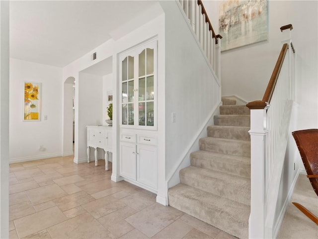 24822 Cutter, Laguna Niguel, CA 92677 - staircase with arched walkways, baseboards, and stone tile flooring