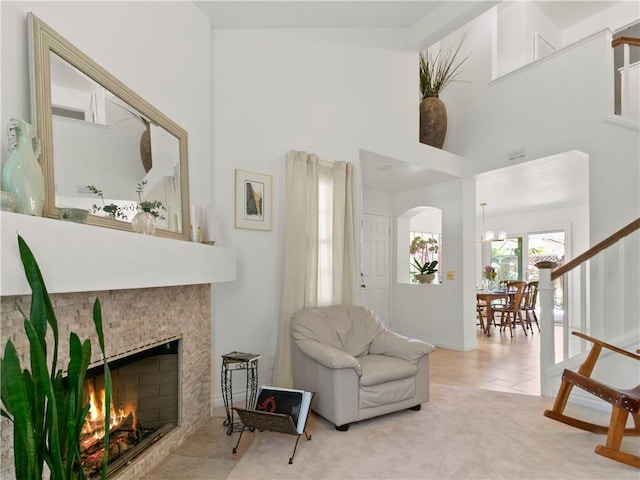24822 Cutter, Laguna Niguel, CA 92677 - tiled living room featuring a towering ceiling, arched walkways, a warm lit fireplace, and a chandelier