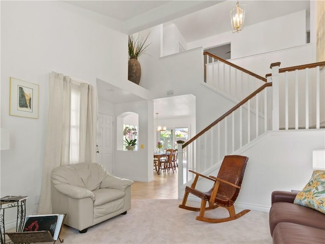 24822 Cutter, Laguna Niguel, CA 92677 - tiled living room with a towering ceiling, baseboards, arched walkways, a chandelier, and stairway
