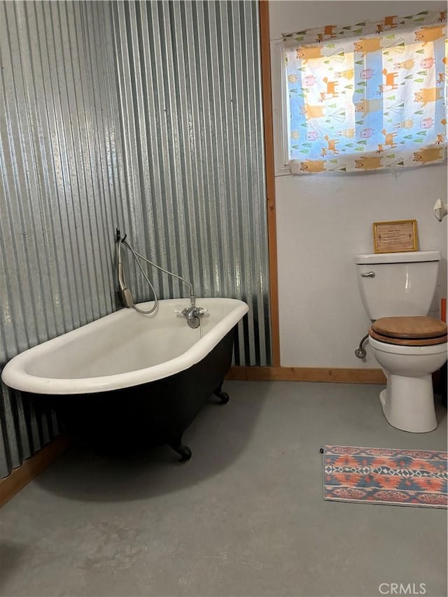 3940 Morongo Rd Unit 29, Palms, CA 92277 - full bath featuring toilet, wallpapered walls, a freestanding tub, concrete flooring, and baseboards