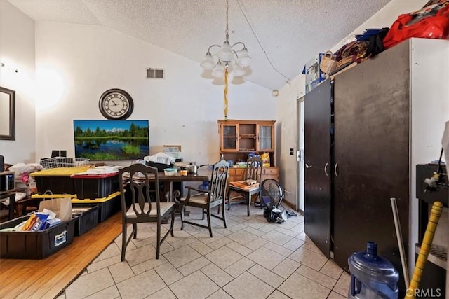 435 Leverett Ave, La Puente, CA 91744 - dining space with lofted ceiling, a textured ceiling, a chandelier, and tile patterned flooring