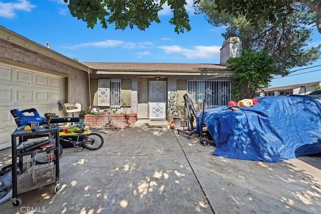 435 Leverett Ave, La Puente, CA 91744 - view of front of home with stucco siding, an attached garage, and a chimney