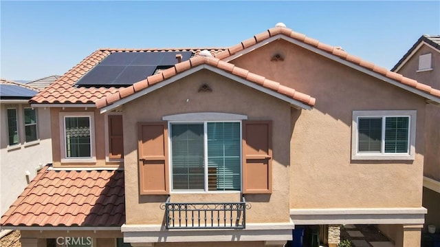 15148 Ridge Ln Unit 4, Fontana, CA 92336 - view of front of home featuring a tile roof, roof mounted solar panels, and stucco siding