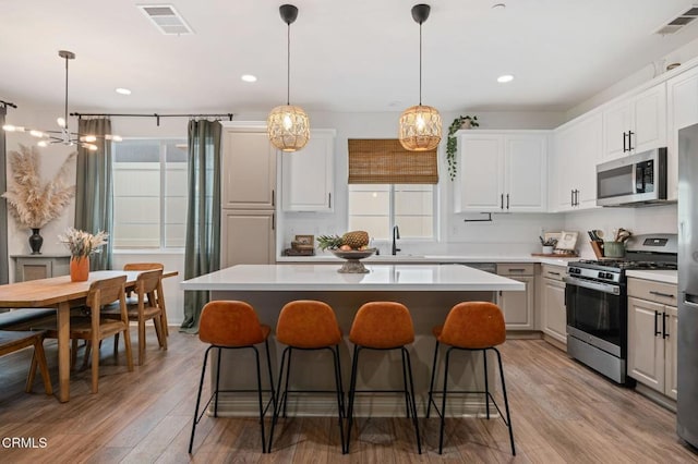 345 Allen Dr, Santa Paula, CA 93060 - kitchen with appliances with stainless steel finishes, a sink, a breakfast bar area, a center island, and light wood finished floors