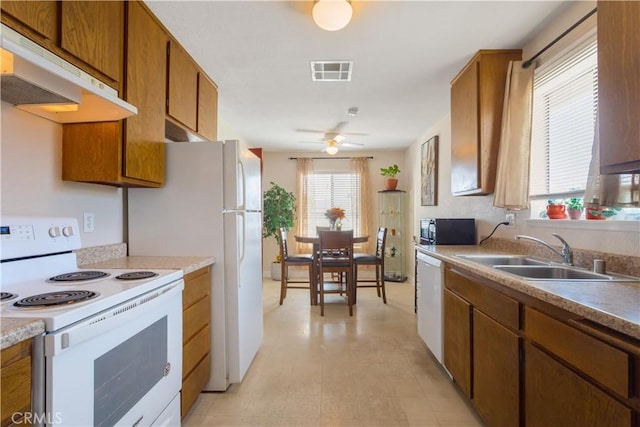 28001 Winged Foot Dr, Menifee, CA 92586 - kitchen with white appliances, a sink, under cabinet range hood, and brown cabinets