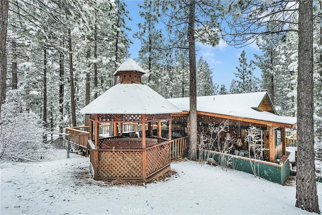 snow covered back of property with a gazebo