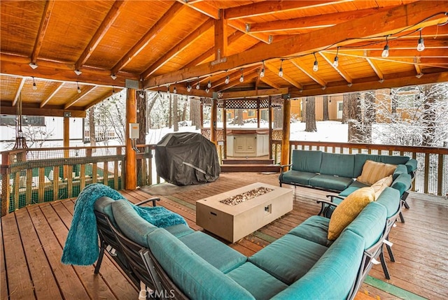 snow covered deck featuring an outdoor living space with a fire pit and a grill