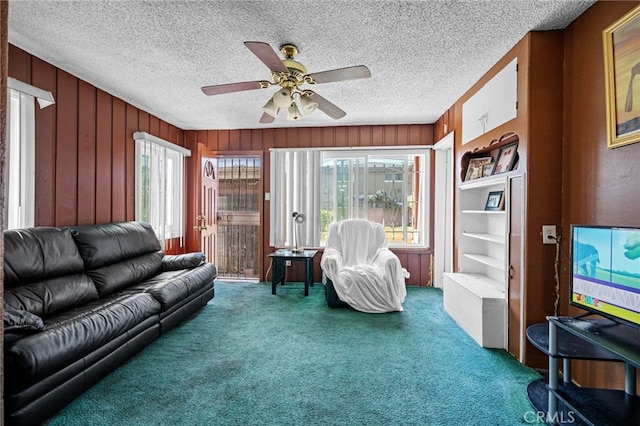 1022 W 101st St, Los Angeles, CA 90044 - carpeted living room with ceiling fan, wooden walls, and a textured ceiling