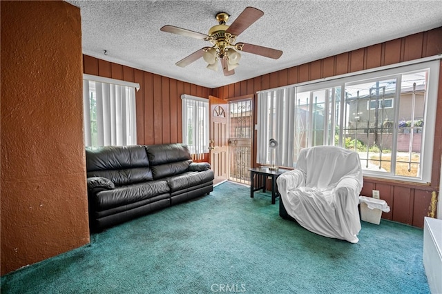 1022 W 101st St, Los Angeles, CA 90044 - carpeted living area featuring ceiling fan, a textured ceiling, wood walls, and a textured wall