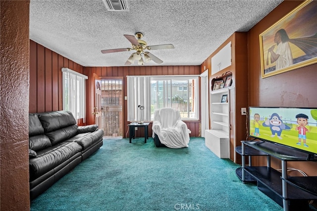 1022 W 101st St, Los Angeles, CA 90044 - carpeted living room with a ceiling fan, wooden walls, and a textured ceiling