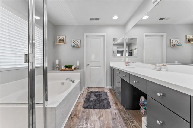 3039 Cayenne Way, Perris, CA 92571 - full bath with vanity, a bath, wood finished floors, recessed lighting, and an enclosed shower