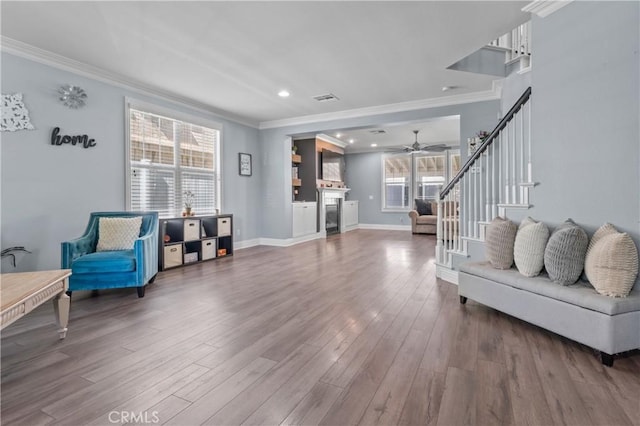 3039 Cayenne Way, Perris, CA 92571 - living area with crown molding, stairway, wood finished floors, a ceiling fan, and baseboards