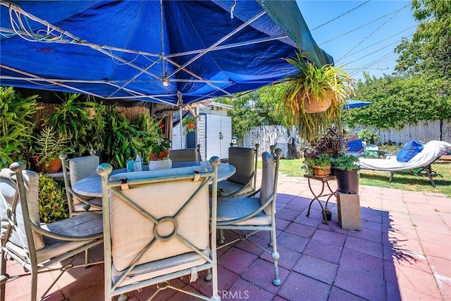 8748 Sylmar Ave, Panorama City, CA 91402 - view of patio featuring outdoor dining area, a fenced backyard, an outbuilding, and a storage shed