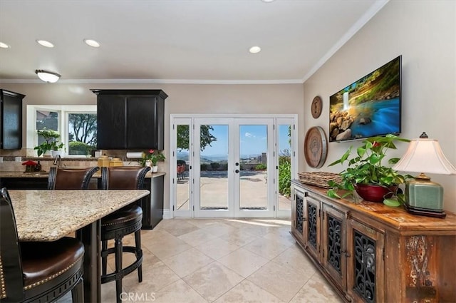 26780 Camino Seco, Temecula, CA 92590 - kitchen with french doors, dark cabinetry, ornamental molding, light stone countertops, and light tile patterned floors