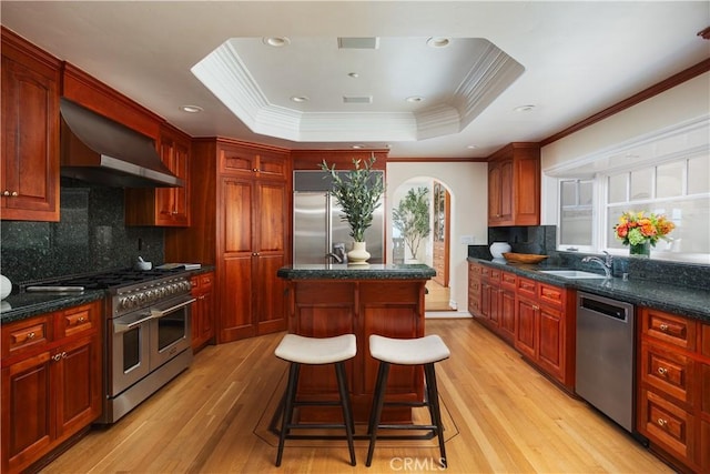 24352 Santa Clara Ave, Dana Point, CA 92629 - kitchen with premium appliances, wall chimney range hood, a center island, ornamental molding, and light wood finished floors