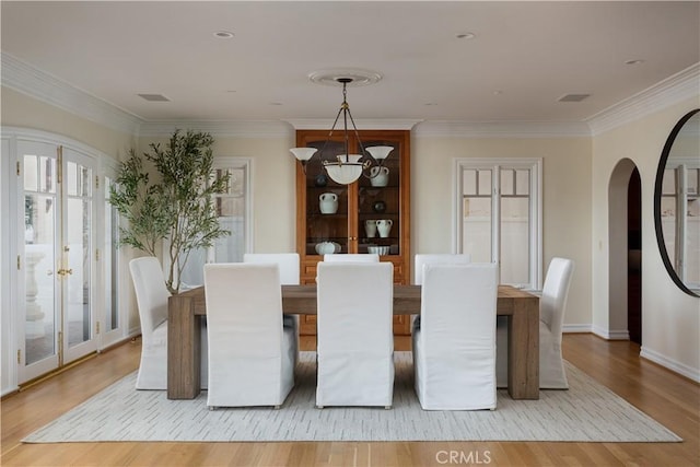 24352 Santa Clara Ave, Dana Point, CA 92629 - dining room featuring arched walkways, light wood-style flooring, ornamental molding, french doors, and a chandelier